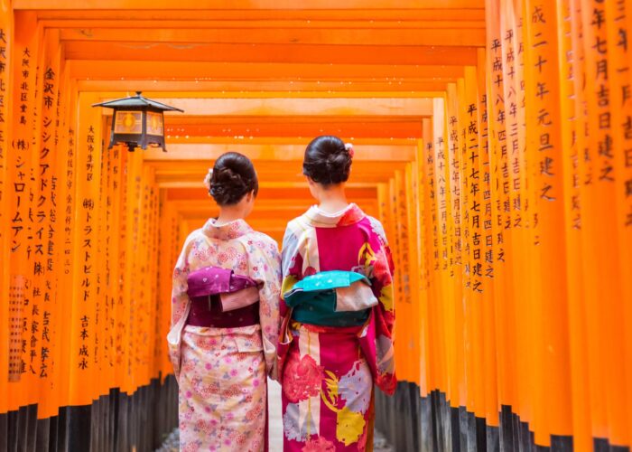 Due donne in kimono nel tunnel di torii vermigli (Senbon Torii) del Santuario Fushimi Inari Taisha, Kyoto, Giappone