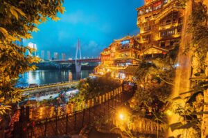 Complesso di edifici tradizionali illuminati di Hongyadong sul fiume all'ora blu, Chongqing, Cina