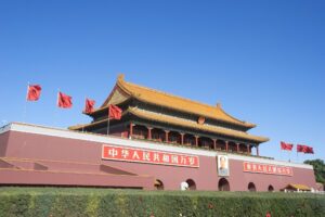 Porta Tiananmen con bandiere rosse e ritratto sotto il cielo terso, Pechino, Cina