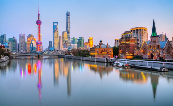 Skyline di Pudong con la Oriental Pearl Tower e la Shanghai Tower riflessi all'ora blu, Shanghai, Cina
