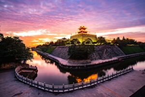 Torre d'angolo delle antiche mura di Xi'an con il fossato al tramonto, provincia dello Shaanxi, Cina
