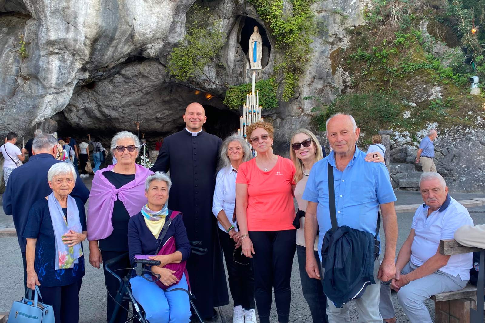 Gruppo di pellegrini con il sacerdote accompagnatore alla Grotta di Lourdes